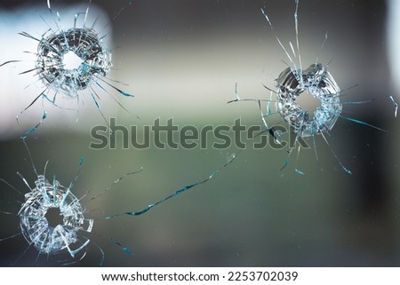 Collage of cracks in the glass, a hole from bullets in the glass on a black background. Window glass texture.