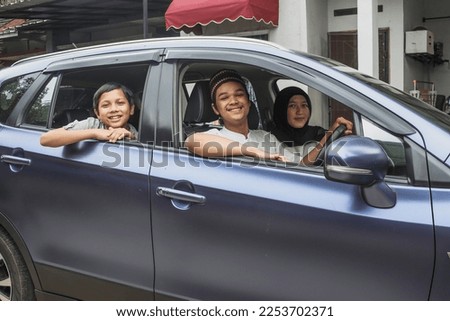 Smiling family muslim inside the car ready to go on holiday. Mudik lebaran at Eid moment.  Royalty-Free Stock Photo #2253702371