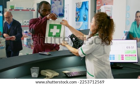 Male customer using mobile phone to pay with nfc for supplements pills, holding smartphone to pos terminal at drugstore counter. Male client buying pharmaceutics and vitamins at pharmacy. Royalty-Free Stock Photo #2253712569