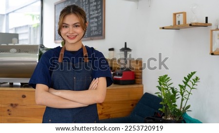 Young woman coffee shop owner holds an open sign.