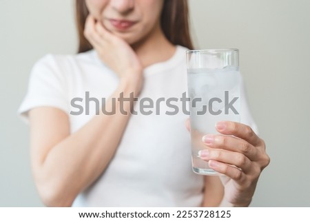 Face expression suffering from sensitive teeth, Asian young woman touching cheek
