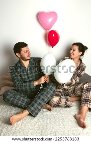 Couple of lovers holds balloons in the shape of a heart. The concept of Valentine's Day. Front view.