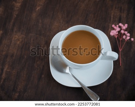 White cup latte coffee on vintage wooden table in morning