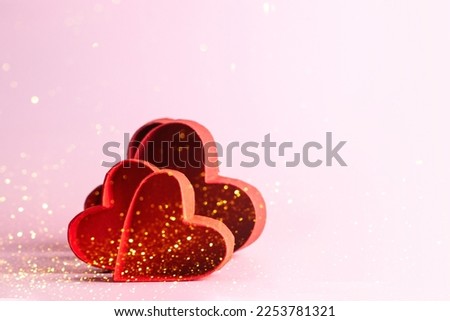 Red hearts on pink background with golden particles for festive image with copy space. Royalty-Free Stock Photo #2253781321