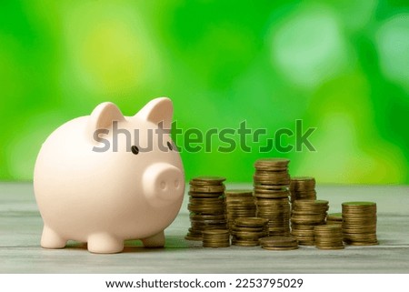 Piggy bank with coin on old wooden table