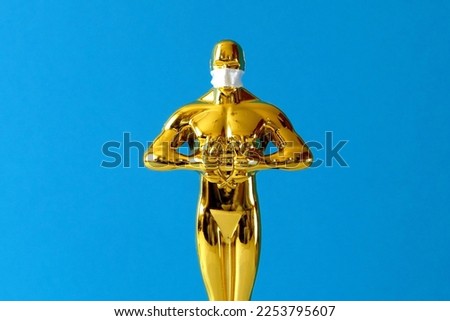 Hollywood Golden Oscar Academy award statue in mask on blue background. Success and victory concept.