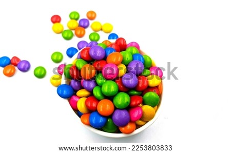 Colorful candies in a bowl isolated on a white background.