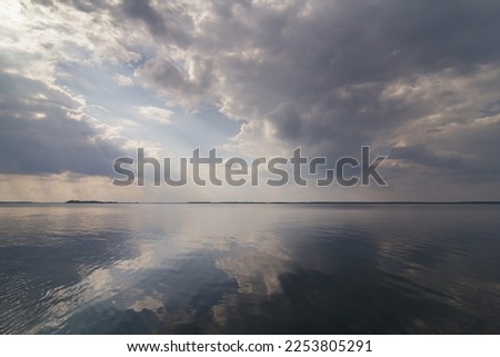 Clouds reflecting on water surface landscape photo. Beautiful nature scenery photography with skyline on background. Idyllic scene. High quality picture for wallpaper, travel blog, magazine, article