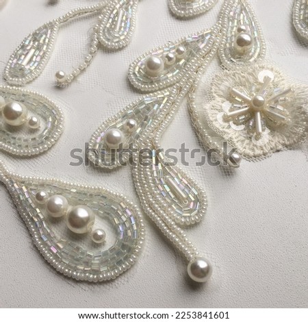 Background of embroidery with pearl beads and sequins Royalty-Free Stock Photo #2253841601