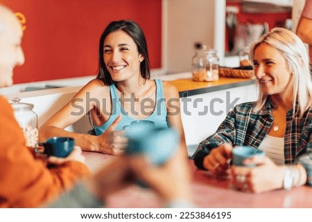 friends in a co-living space relaxing with a cup of coffee and chatting together Royalty-Free Stock Photo #2253846195