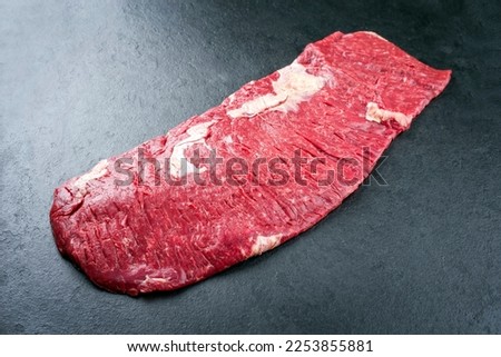 Raw wagyu bavette beef steak offered as top view on rustic black board with copy space Royalty-Free Stock Photo #2253855881