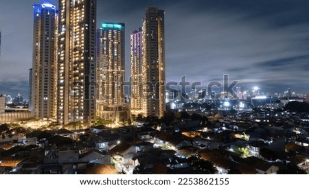 multiple skyscraper buildings among homes shot at nighttime  over dramatic sky above them