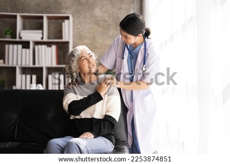 Young caregiver helping senior woman walking. Nurse assisting her old woman patient at nursing home. Senior woman with walking stick being helped by nurse at home.