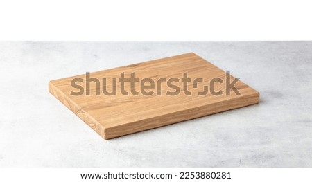 Cutting board on a grey stone table. Isolated on a white background. Culinary background. Empty wooden cutting board, product display space. Royalty-Free Stock Photo #2253880281