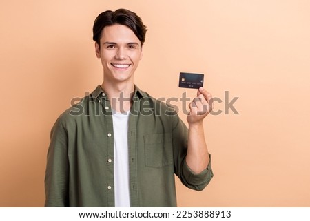 Photo of nice positive person beaming smile arm hold plastic debit card isolated on beige color background