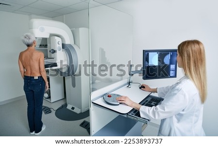 Mammogram procedure. Preventive diagnostic of senior woman by radiologist using mammography workstation to receive mammogram at radiology room Royalty-Free Stock Photo #2253893737