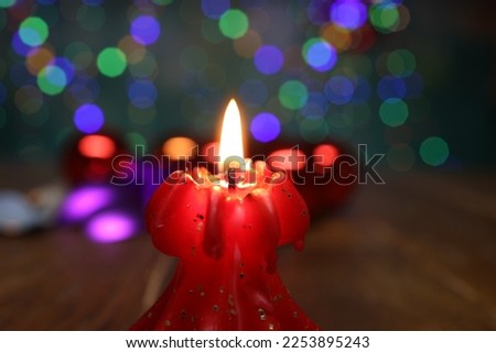New Years motive. Burning candle on a blurred background