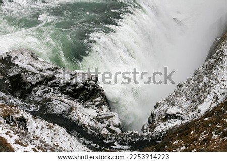 The waterfall in Iceland is from a nature reserve, the photo was taken in the winter season. You can see the snow on the rocks.