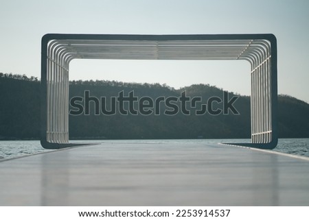 Frame, a picture made of wood by the water in the middle of the mountains.