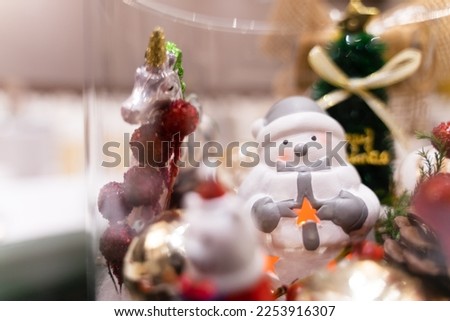 White snowman with Christmas tree and unicorn under soft light.