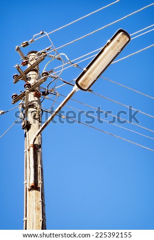 streetlamp and electric cables in front of blue sky