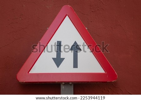 Two Way Traffic Sign on Red Wall
