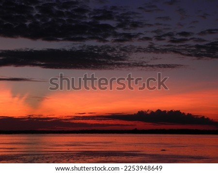 Amazon skies. Sunset with tubular clouds and sky with pink orange and yellow tones over the Negro river