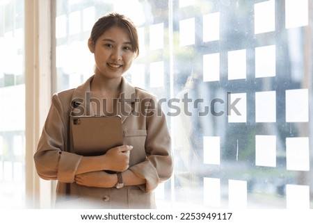 Portrait of a charming young Asian business woman in the office looking and smiling.