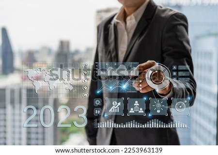 Businessman with a modern visual screen global network connection Graph analyzing financial growth and 2023 investment data planning concept