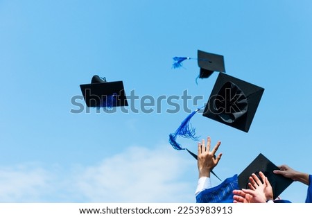 Graduating students hands throwing graduation caps in the air. Royalty-Free Stock Photo #2253983913