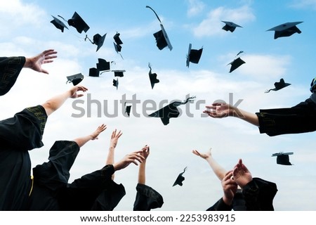 Graduating students hands throwing graduation caps in the air. Royalty-Free Stock Photo #2253983915