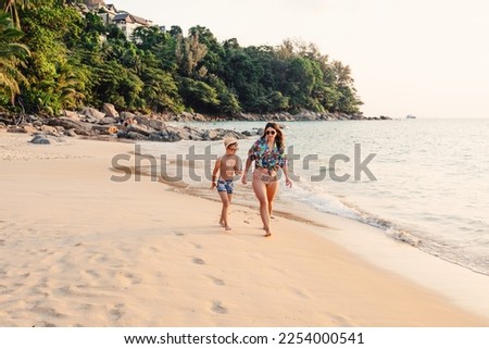 Mother and son walking on the Naithon beach in Phuket 