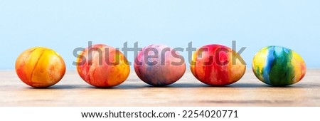 Colorful Easter eggs on a wooden background with a place for text. Happy Easter concept. Banner