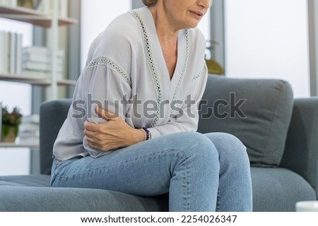 Flatulence caucasian mature adult, senior woman hand in stomach ache, suffer from food poisoning, abdominal pain and colon problem, gastritis or diarrhoea. Patient belly, abdomen or inflammation. Royalty-Free Stock Photo #2254026347