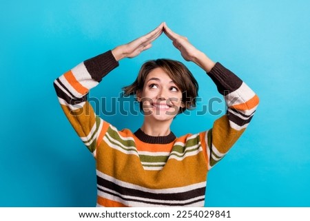 Photo of thoughtful dreamy lady wear striped sweater showing arms roof looking empty space isolated blue color background