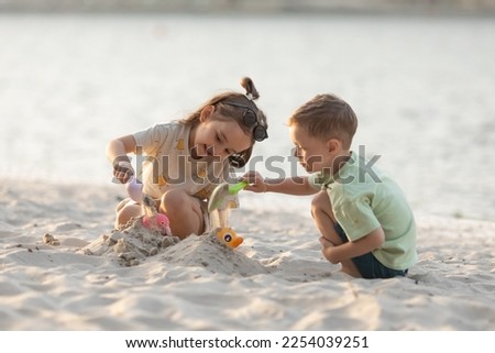 Children boy and girl playing on the beach on summer holidays. Children having fun with a sand on the seashore. Vacation concept. Happy sunny day Royalty-Free Stock Photo #2254039251