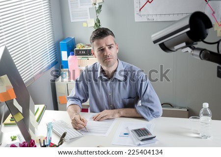 White collar at office desk working with surveillance camera on foreground. Royalty-Free Stock Photo #225404134