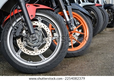 Front wheels of several mopeds - closeup of brake discs Royalty-Free Stock Photo #2254082379