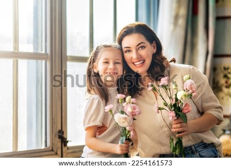 Happy mother's day. Child daughter congratulating her mother and giving her bouquet of flowers. Royalty-Free Stock Photo #2254161573