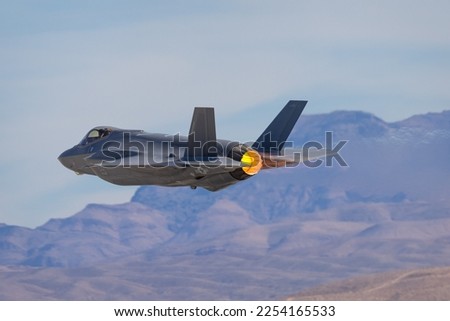 Extremely close view of a F-35 Lightning II against the Nevada hills, with afterburner on Royalty-Free Stock Photo #2254165533
