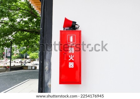 Fire extinguisher sign on red box in the building corridor,The word "fire extinguisher" in Japanese.