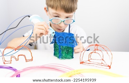 boy playing with 3 d pen. High quality photo Royalty-Free Stock Photo #2254195939