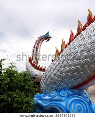 Wat Khao Sung Chaem Fa Located in Kanchanaburi Province, Thailand, is a temple with many large buildings. There is a big Buddha image There are large and very long statues of dragons and serpents. whi Royalty-Free Stock Photo #2254206293