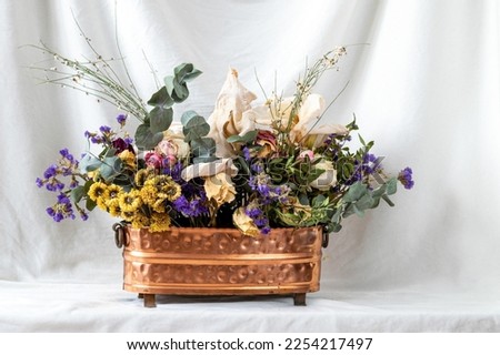 composition of dry flowers in a vase, white fabric background, still life with dry flowers