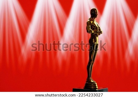 Hollywood Golden Oscar Academy award statue on red  background with light rays. Success and victory concept.