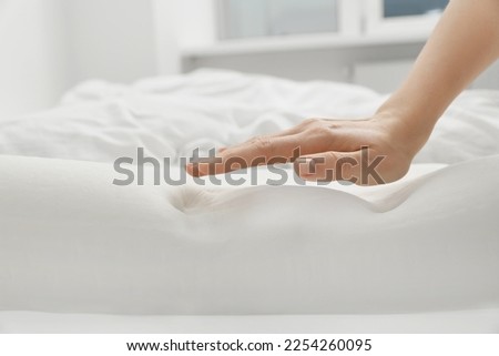 Woman with orthopedic memory foam pillow on bed, closeup. Space for text Royalty-Free Stock Photo #2254260095