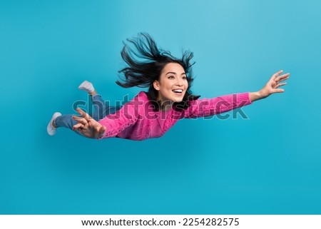 Full length photo of adorable pretty lady wear pink pullover falling air isolated blue color background Royalty-Free Stock Photo #2254282575