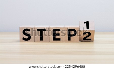 wooden cube block turns step 1 to 2 on a table top for step-by-step operations. There is a step-by-step way of working.