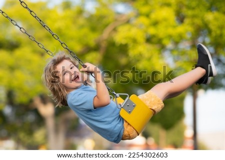 Outdoor playground. Funny kid on swing. Little boy swinging on playground. Happy cute excited child on swing. Cute child swinging on a swing. Crazy playful child swinging very high. Royalty-Free Stock Photo #2254302603