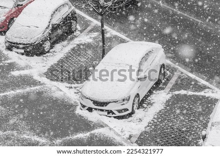 Street background with cars in winter. Snow snowflakes in foreground